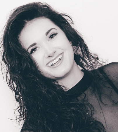 Black and white headshot of smiling woman with long dark hair