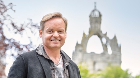 smiling man with kings college in background